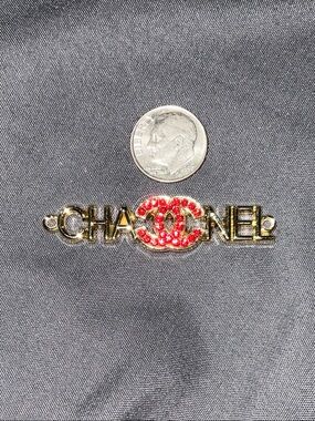 Gold-Tone Brooch with Red Crystal Logo